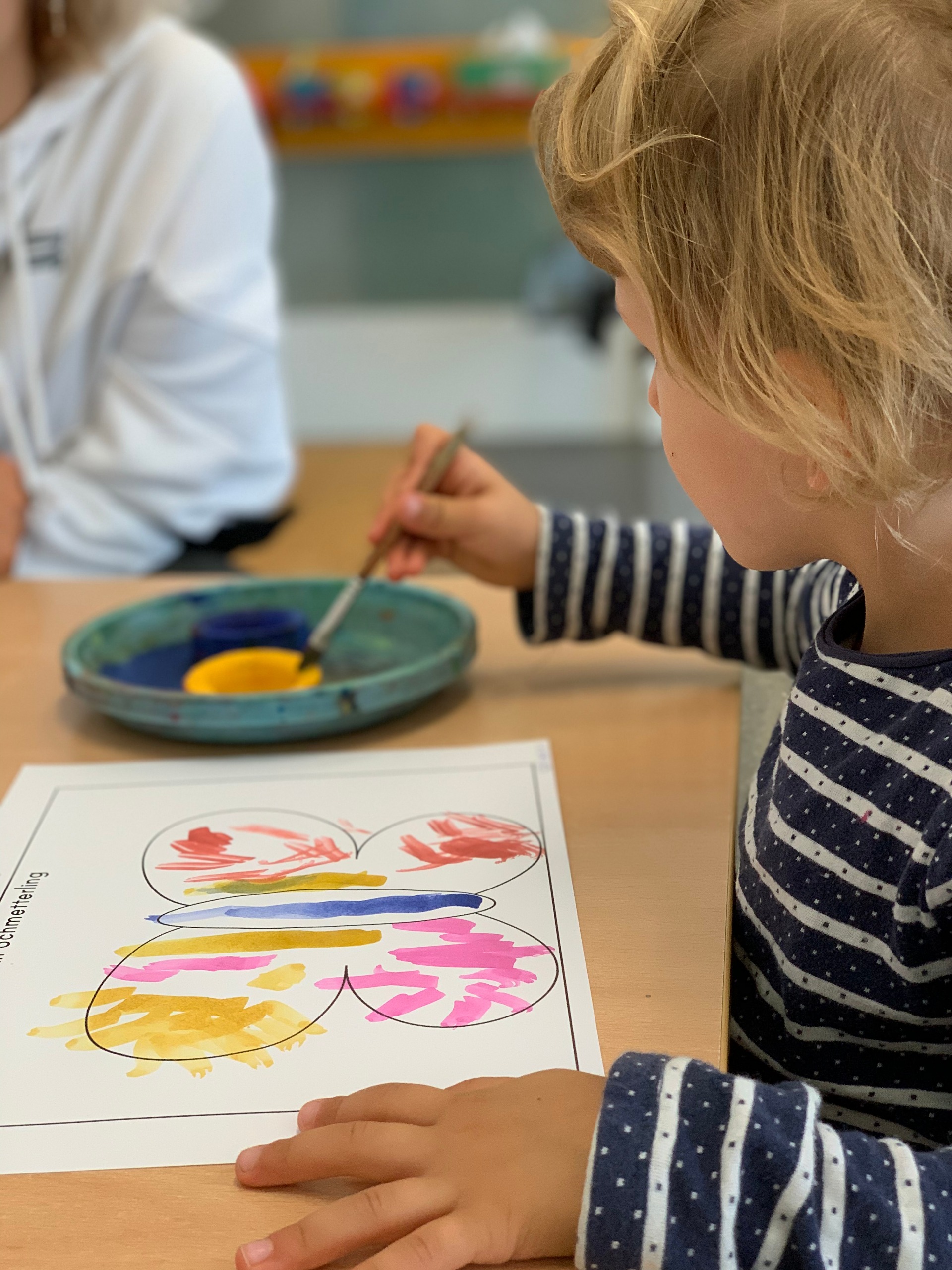 Eine Frau mit zwei Kindern steht vor der Eingangstüre der Feusi in Muri-Gümligen.