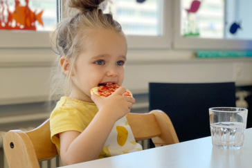 Ein Kind sitzt an einem Tisch und isst.