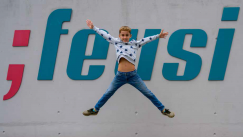 Nino Cavigelli. springt vor Wand mit dem Feusi Logo in die Luft. Er besucht das Gymnasium am Feusi Bildungszentrum in Bern.